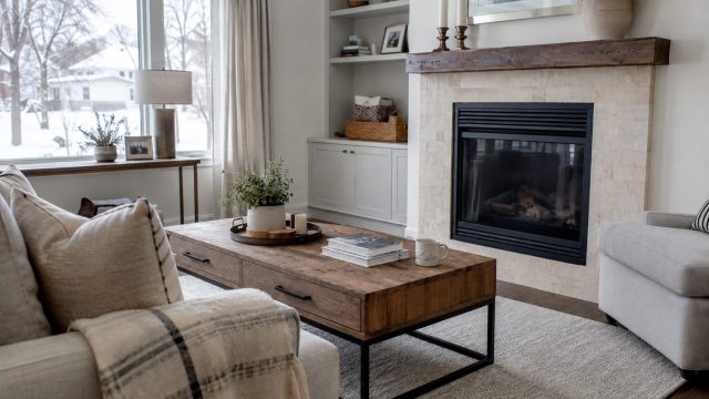 Bright Chicago living room with a fireplace, upholstered seating, hardwood floors, and a snowy residential neighbourhood visible through the window.