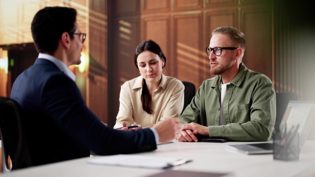 Couple seated across from an attorney during a divorce consultation in a modern law office.