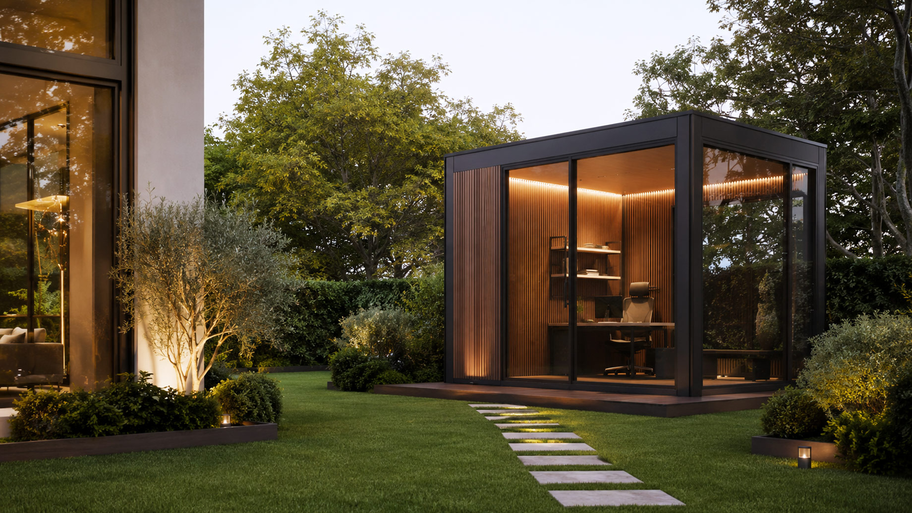Modern glass office pod with timber walls and warm interior lighting positioned in the landscaped garden of a luxury home.