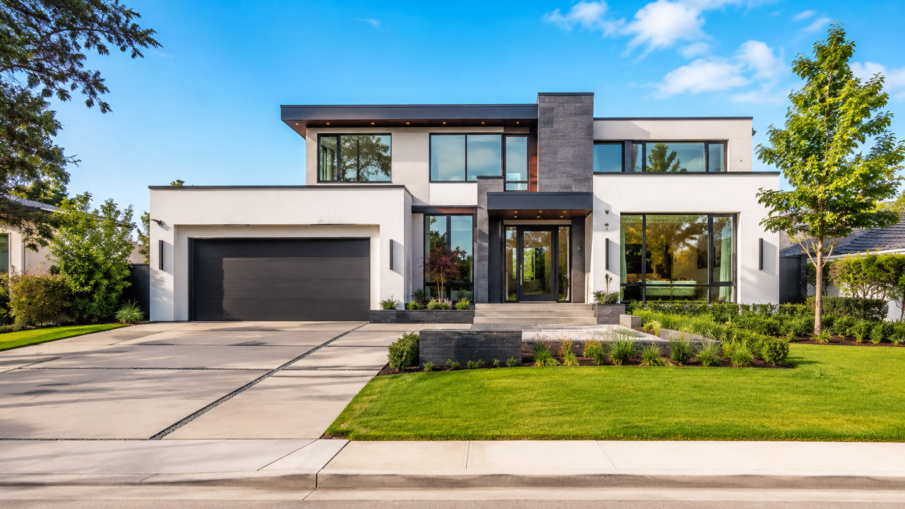 Modern two-storey home with large windows, clean landscaping, a wide driveway, and strong curb appeal on a sunny day.