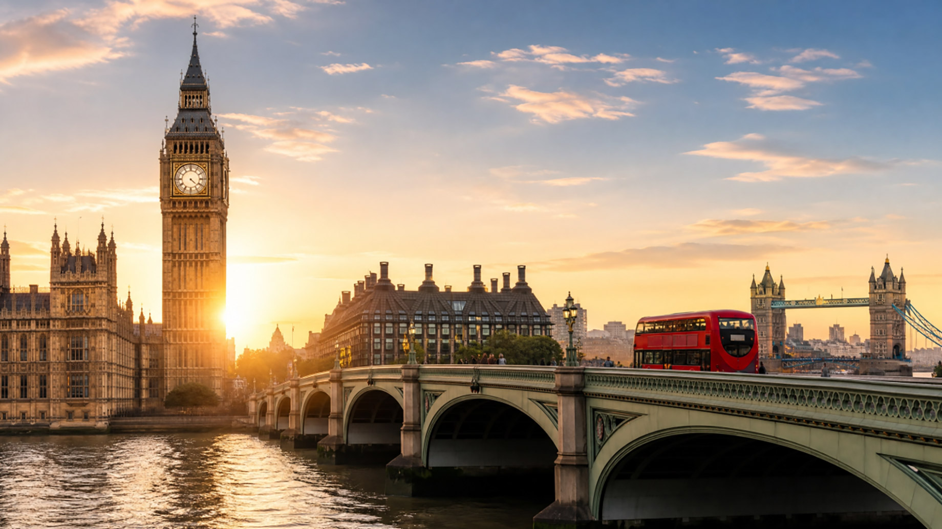 London skyline at sunset with Elizabeth Tower, Westminster Bridge, the River Thames, and a red double-decker bus.