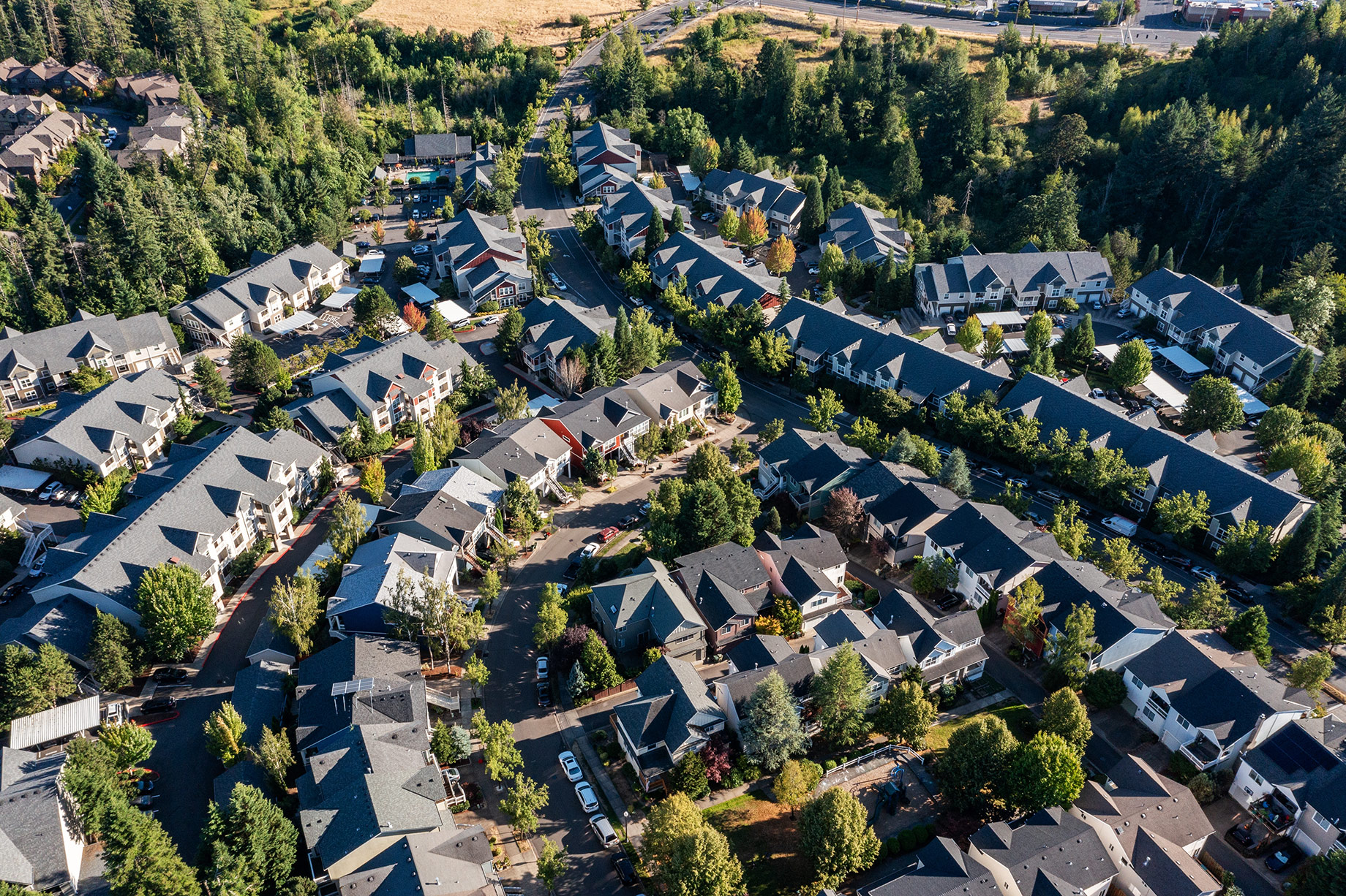 Aerial view of residential homes, apartment communities, tree-lined streets, and green spaces near Beaverton and Portland, Oregon.