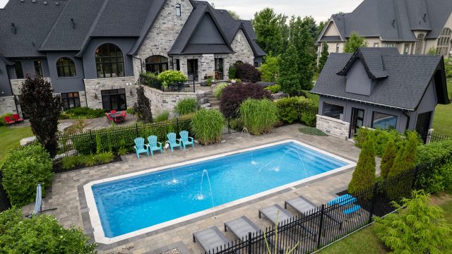 Luxury Toronto home with landscaped backyard, swimming pool, stone patio, privacy planting, and outdoor living areas.