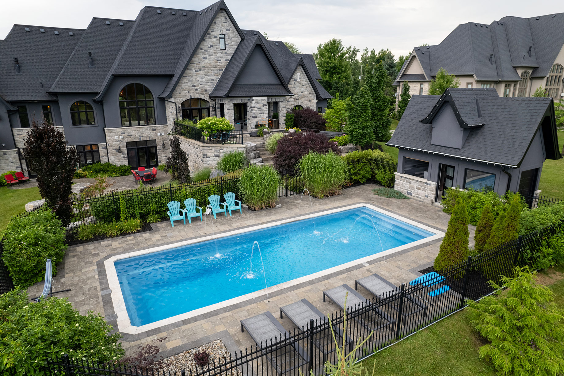 Luxury Toronto home with landscaped backyard, swimming pool, stone patio, privacy planting, and outdoor living areas.
