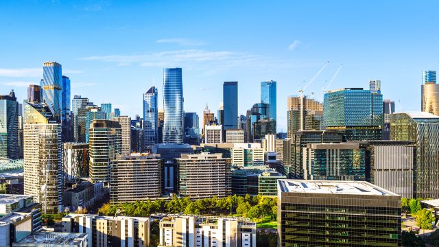 Melbourne CBD skyline featuring modern residential and commercial towers under a clear blue sky.
