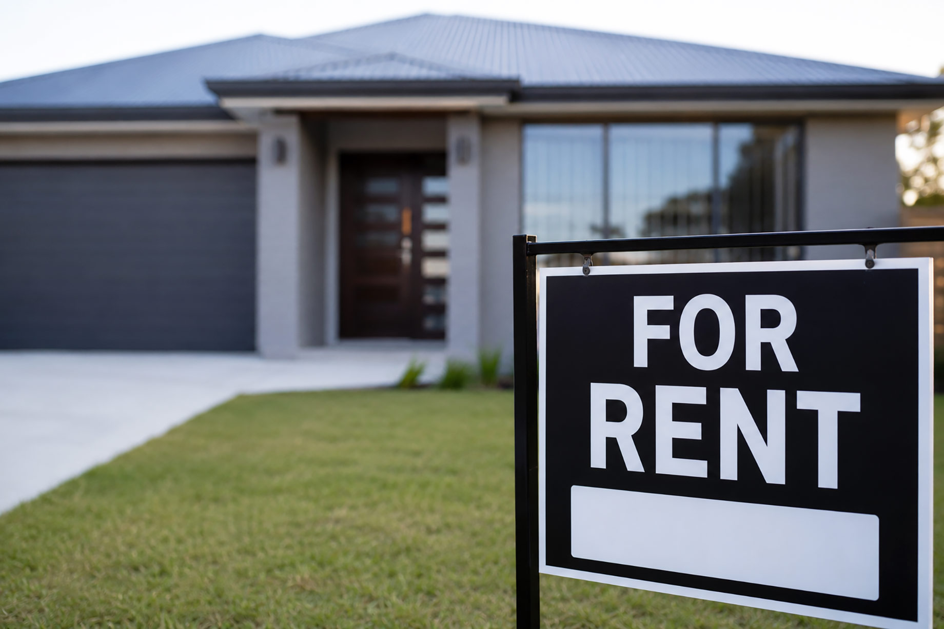 Modern newly built rental home with a For Rent sign displayed on the front lawn.