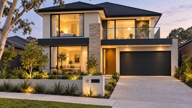 Two-storey home with a glass balcony, stone feature wall, timber entrance, dark double garage, and landscaped front garden at dusk.