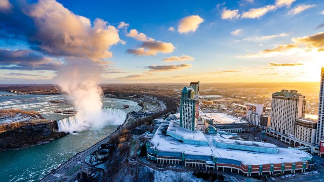 Aerial view of Horseshoe Falls and Fallsview Casino Resort beneath a vivid winter sunset in Niagara Falls, Ontario.