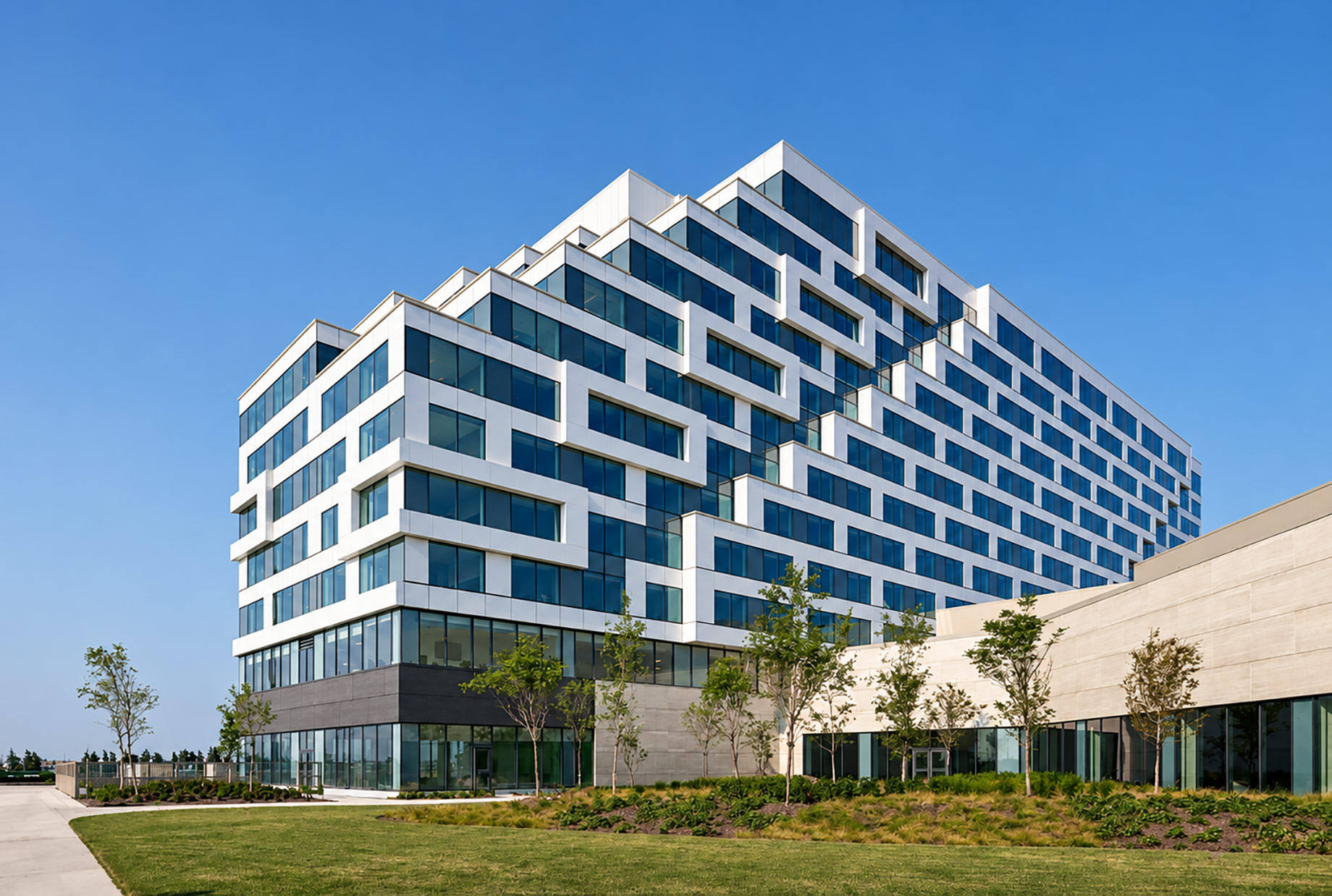 Modern stepped hotel tower with white geometric cladding, blue-tinted windows, and landscaped grounds at Great Canadian Casino Resort Toronto.