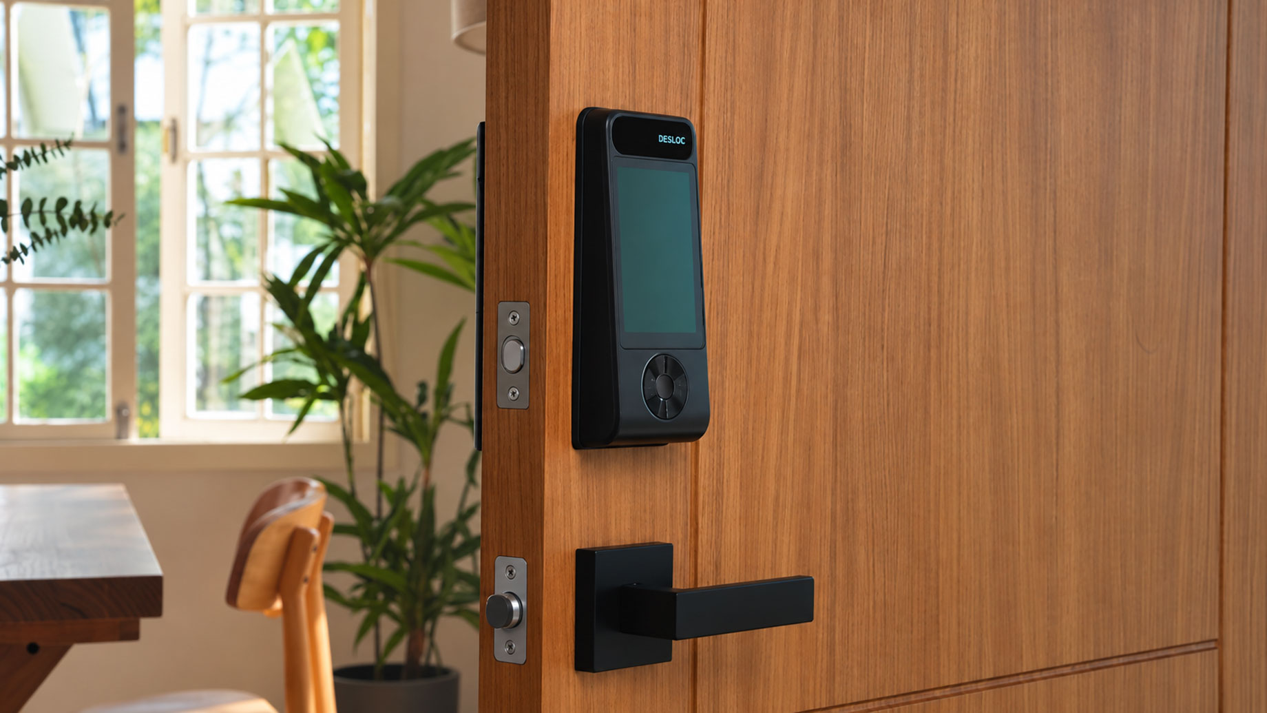 DESLOC V150 Plus smart lock mounted on a modern wooden door with a black lever handle in a bright contemporary home.