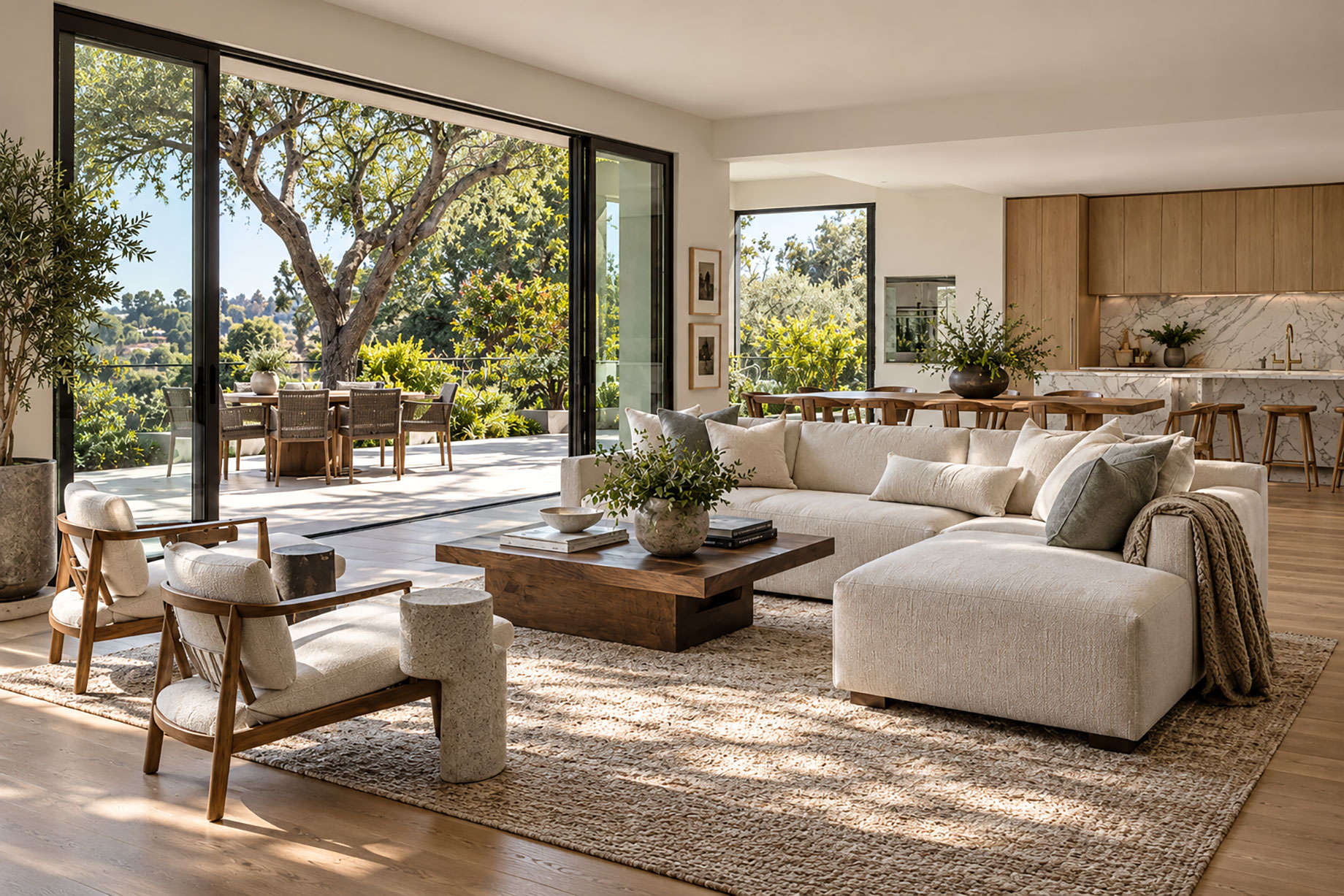 Open-plan living room with a cream sectional, wood kitchen cabinetry, and sliding glass doors opening onto a garden terrace.
