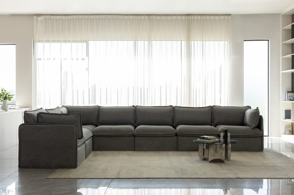 Anabei large L-shaped washable sectional in Ash gray fabric facing floor-to-ceiling windows